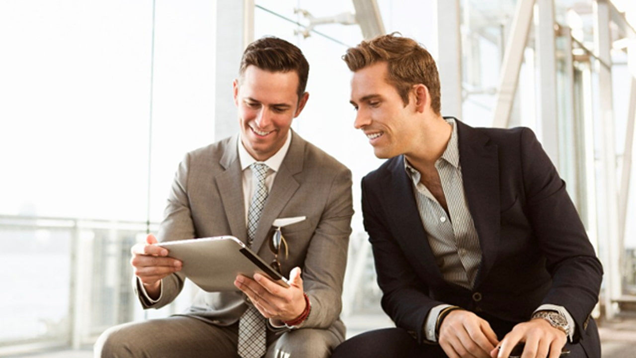 two office workers looking in laptop