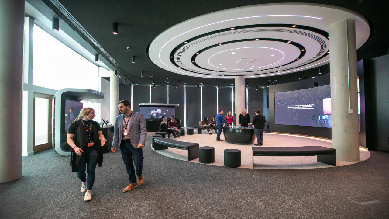 A couple of people walking through a large room