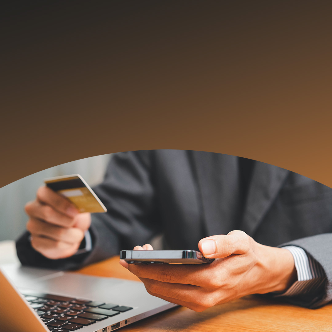 Primo piano di mani maschili che tengono una Carta di credito e uno smartphone.