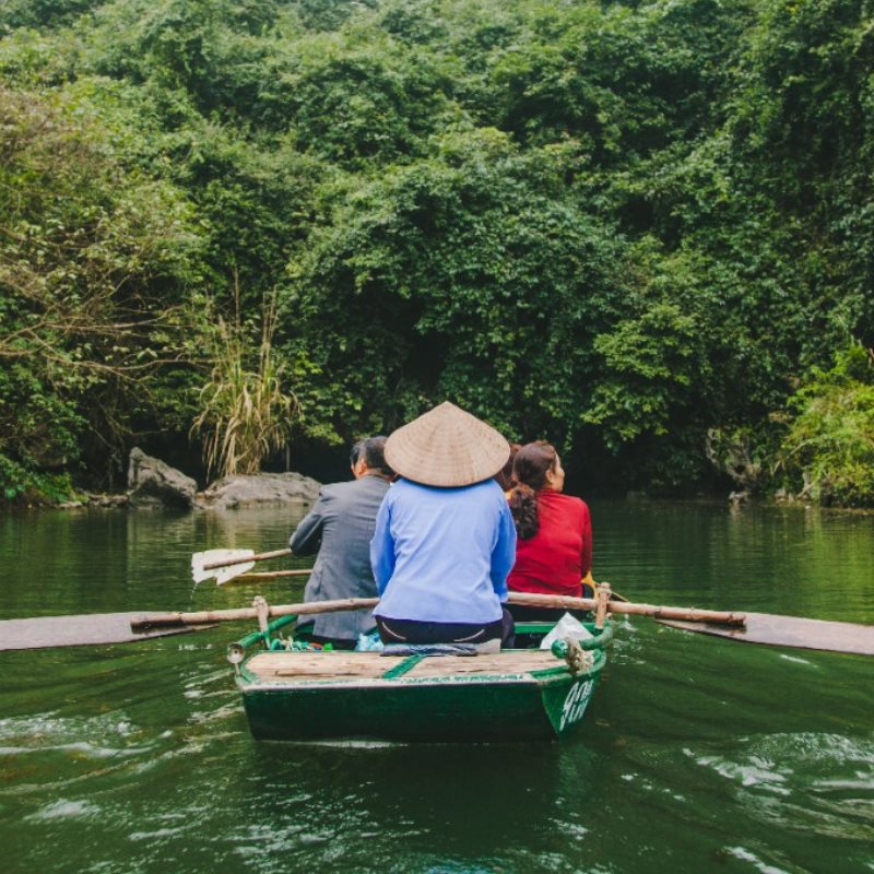 Two tourists take a boat ride on a river in Vietnam.