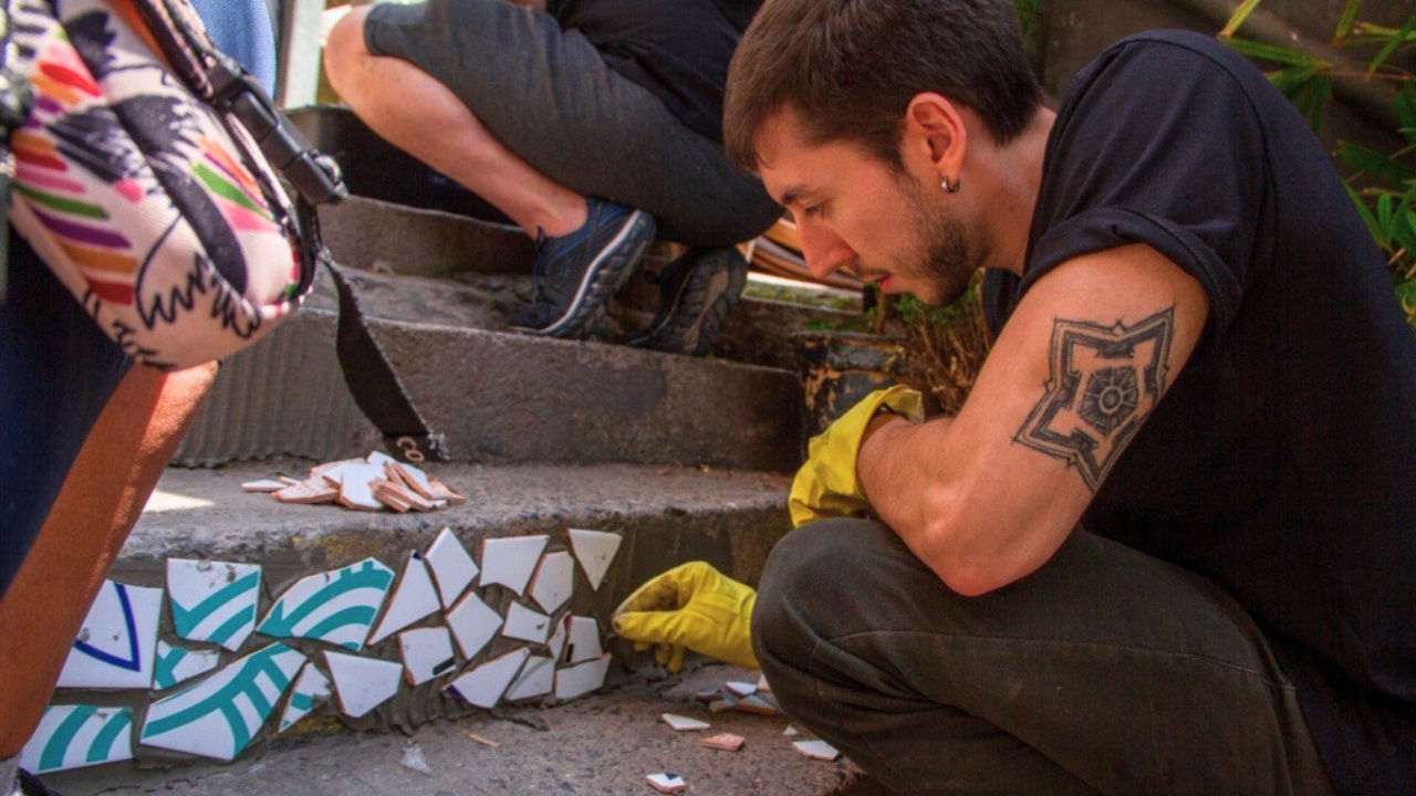  João Moretti applies broken bits of tile to steps. 