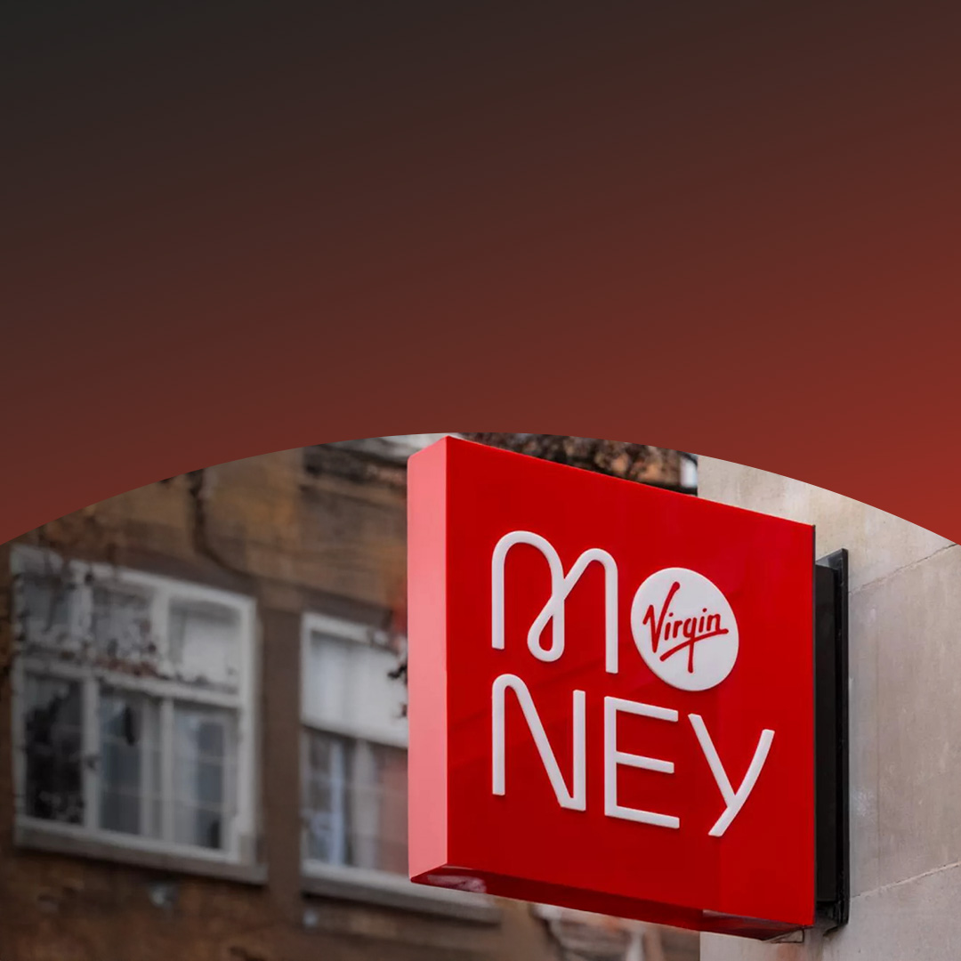 Enseigne Virgin Money rouge et blanche sur la façade d’un bâtiment.