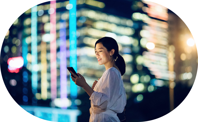 Femme regardant son téléphone en souriant.