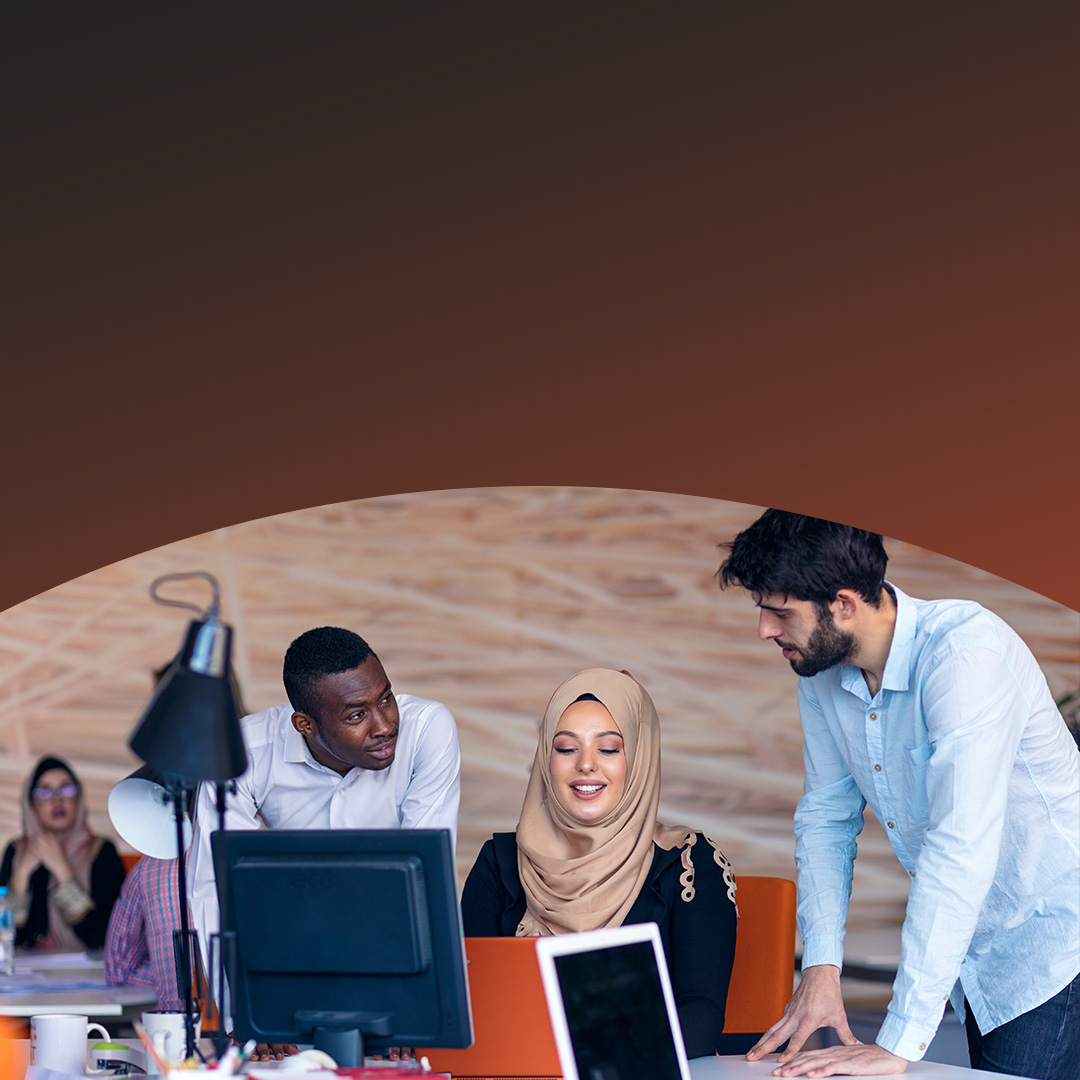 Trei colegi colaborând la un birou. 