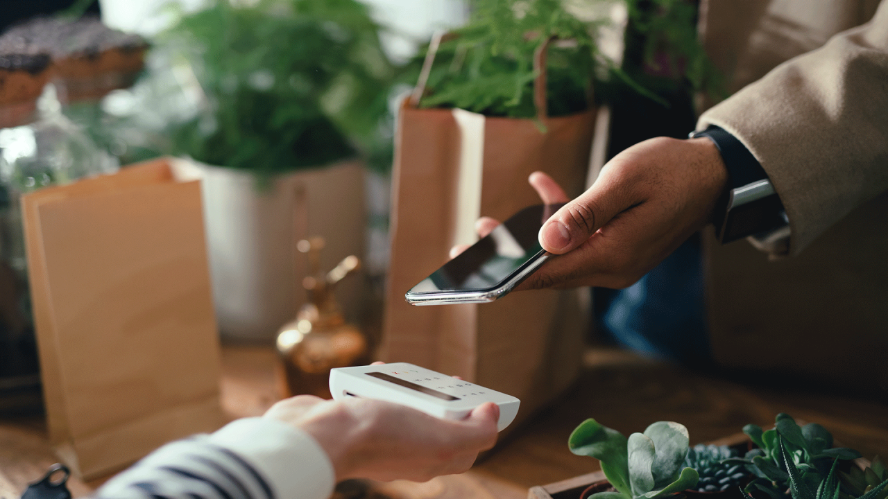 Persoană care efectuează o plată contactless folosind un smartphone.