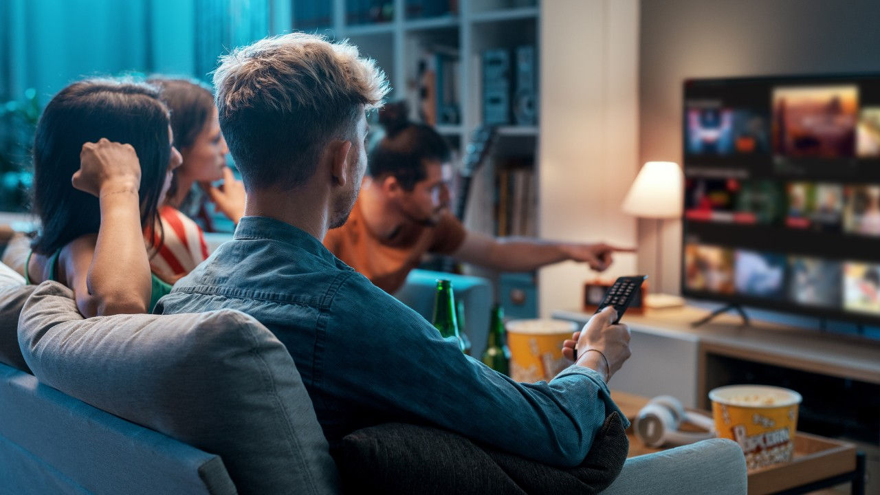 A group of friends watch TV together.