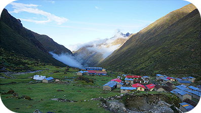 Small settlement in a misty valley between two hills.