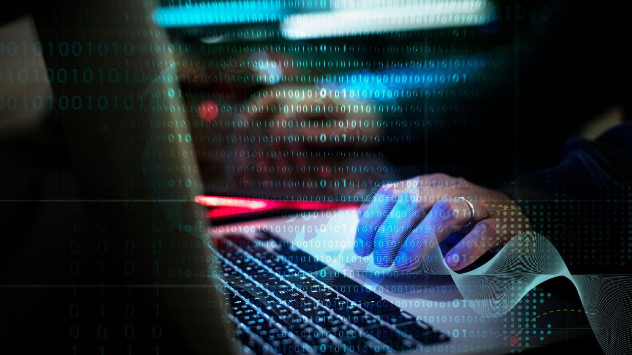 A person types at a laptop with a digital overlay . 