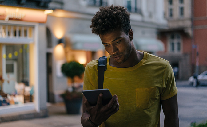Homme regardant son téléphone pour consulter des informations sur l'identité en temps réel.