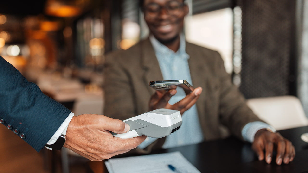 Homme payant son repas par téléphone mobile