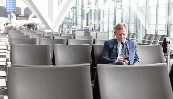 Man looking at phone at airport