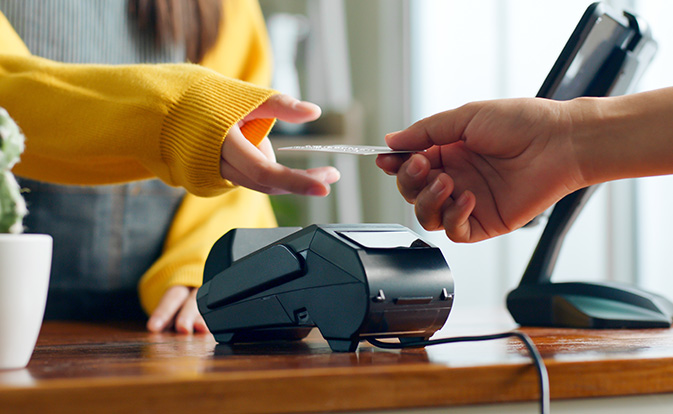 Customer using credit card for payment to owner at cafe