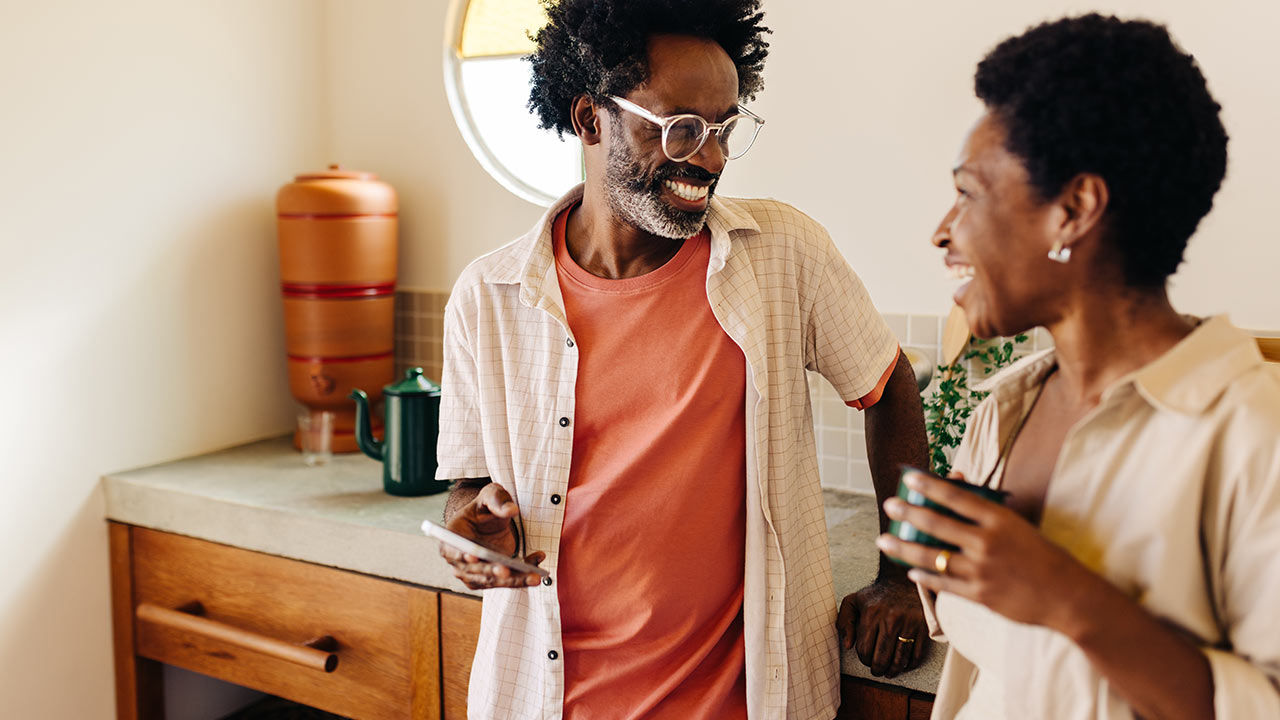 Couple with a mobile phone at home.