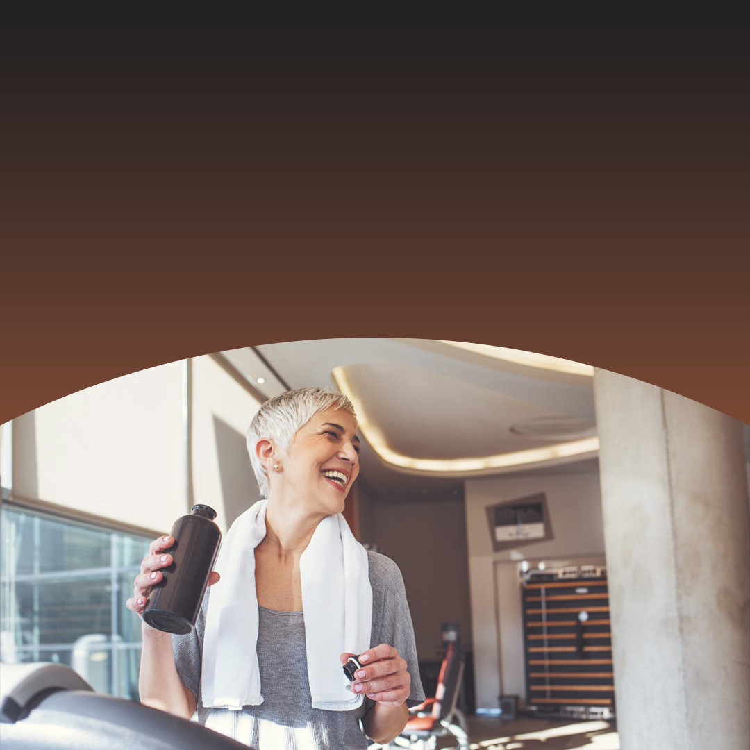 Woman on treadmill holding water bottle.