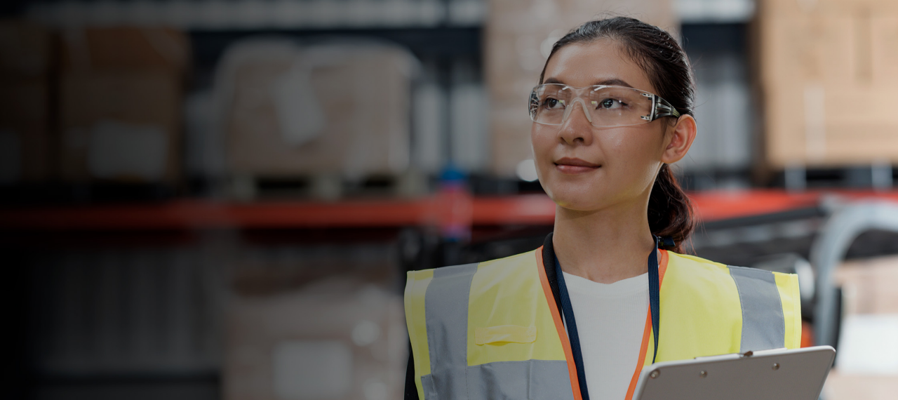 Woman working in a warehouse holding clipboard