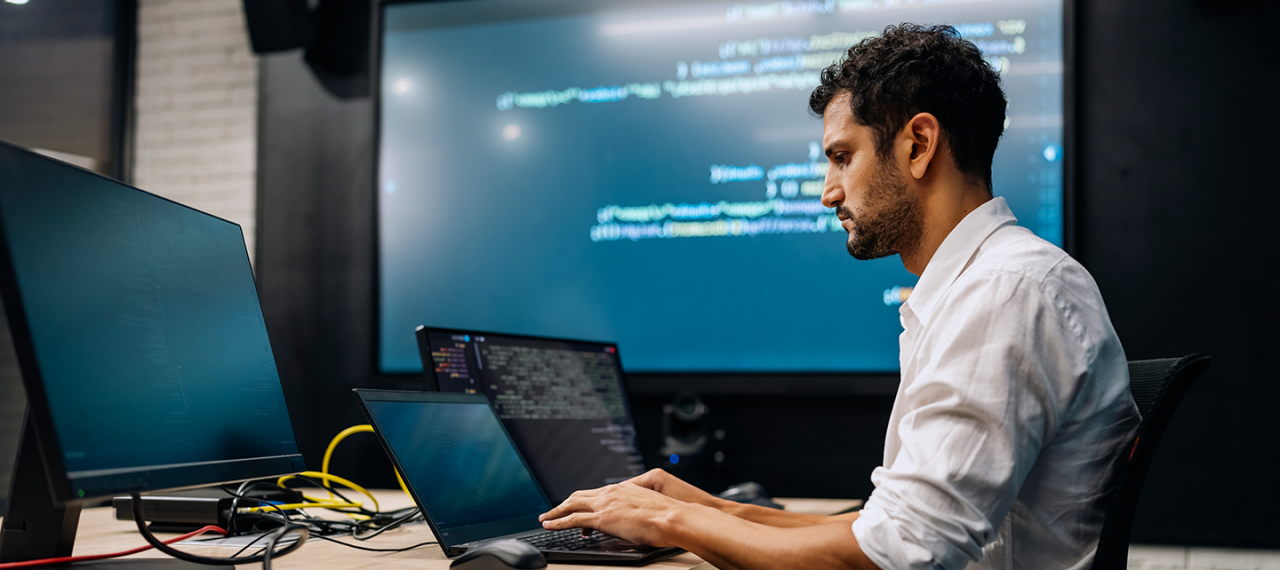 Man on computer typing in office