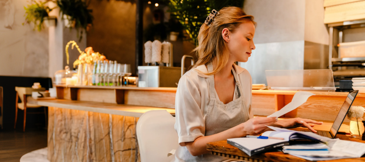 Woman in a restaurant going over the numbers