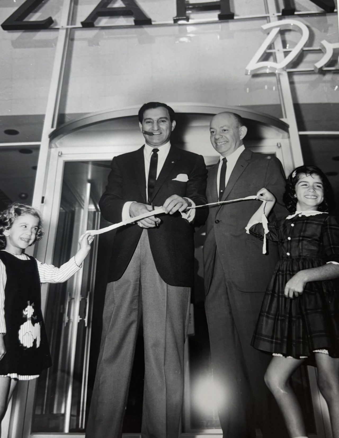 Ginger Siegel, right, poses with her grandfather, Louis Zahn, and entertainer Danny Thomas, at the ribbon-cutting of Zahn's new location. 
