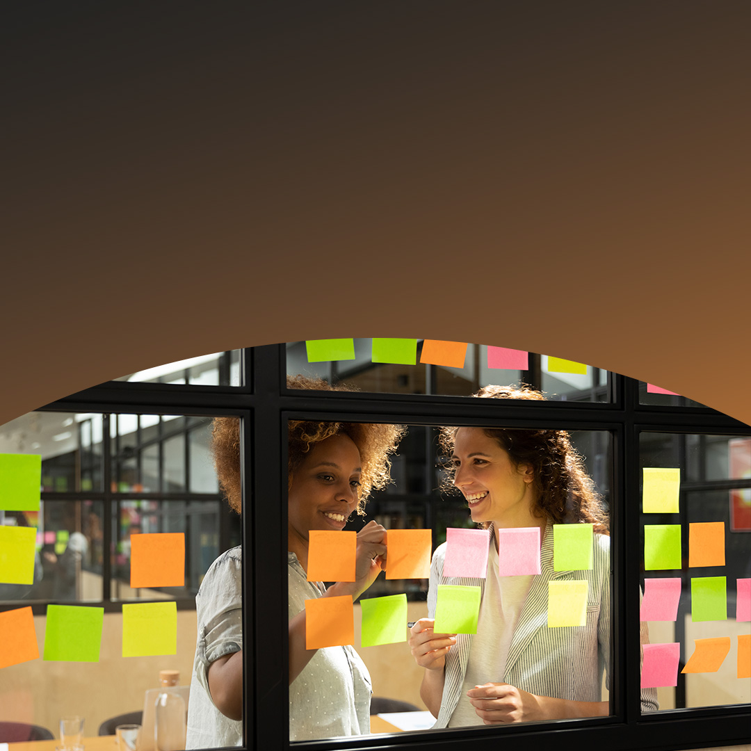 Los colegas de la oficina discuten ideas de negocios mientras escriben en notas adhesivas.