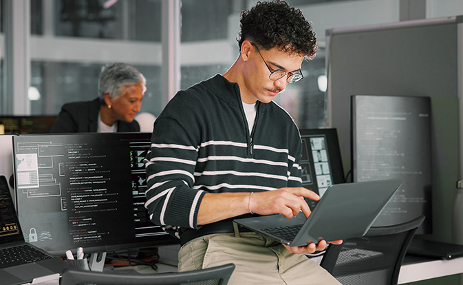Hombre trabajando en una computadora portátil sentado en un escritorio