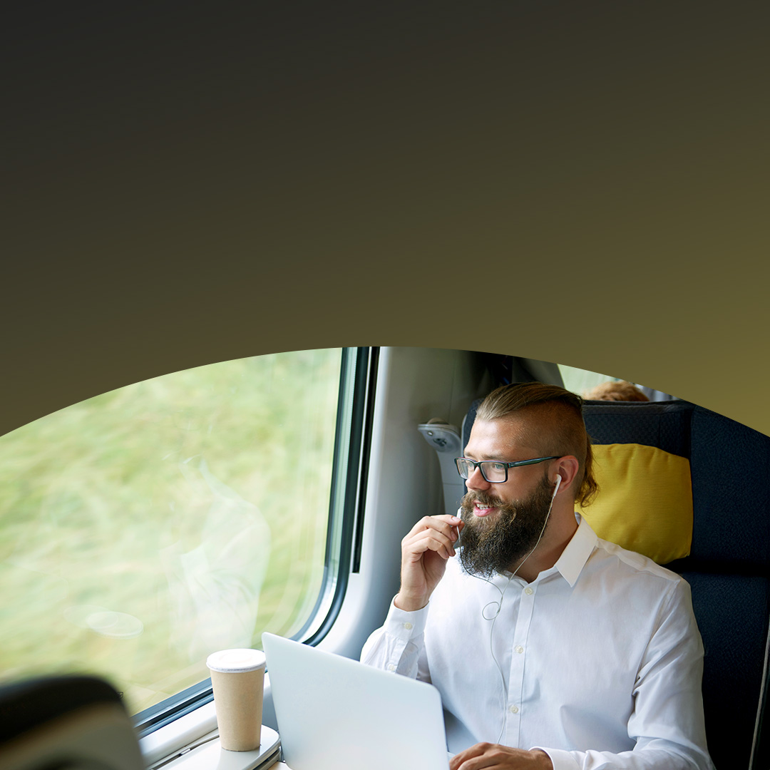 Hombre de negocios viajando en tren usando una computadora portátil.
