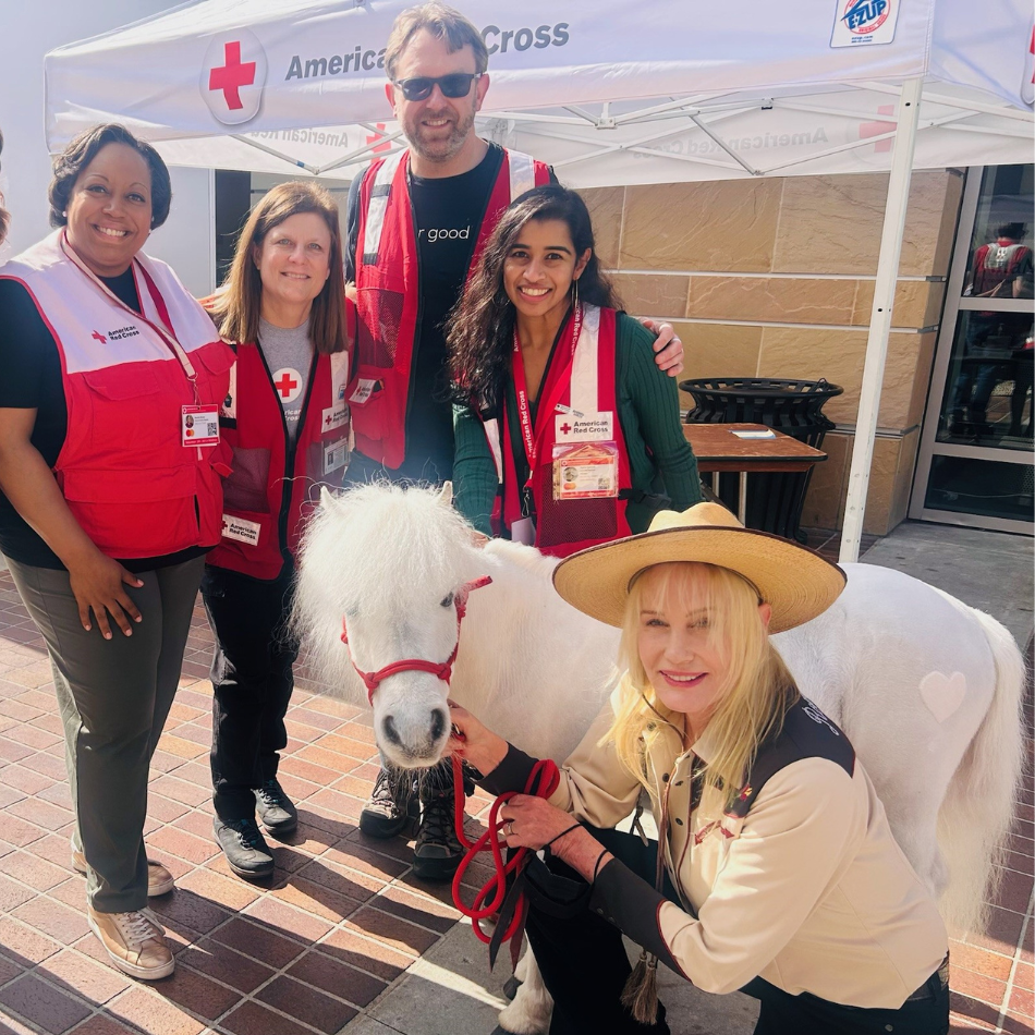 Cuatro voluntarios de la Cruz Roja con la actriz Daryl Hannah y uno de sus ponis Shetland afuera de un refugio de la Cruz Roja.