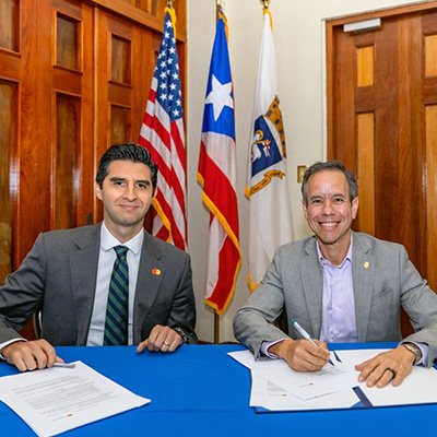 Two men signing an agreement at office.