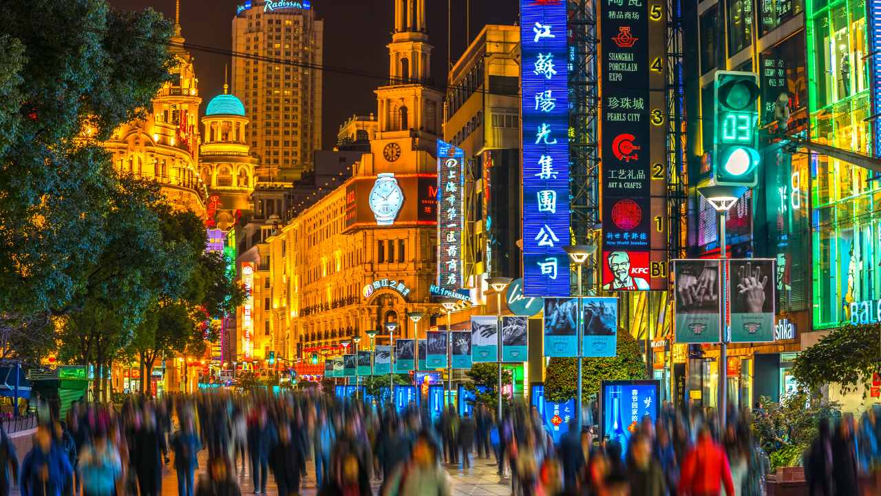 A busy Tokyo street lit by neon lights at night.