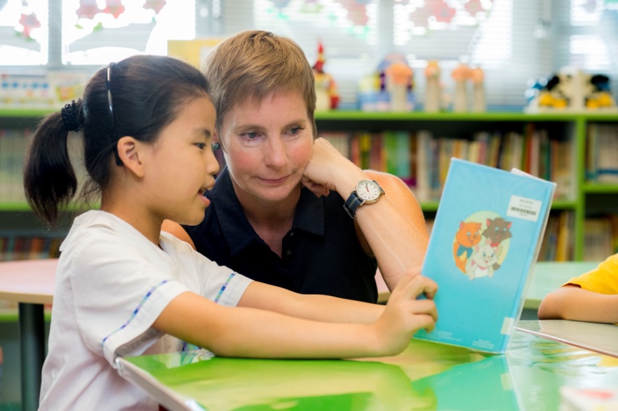 圖片說明 (1): 香港閱讀之家學生互助（青年外展）團隊義工領袖Jodi Mullen探訪佛教慈敬學校並與學生一起閱讀，參與「閱讀馬拉松」活動。