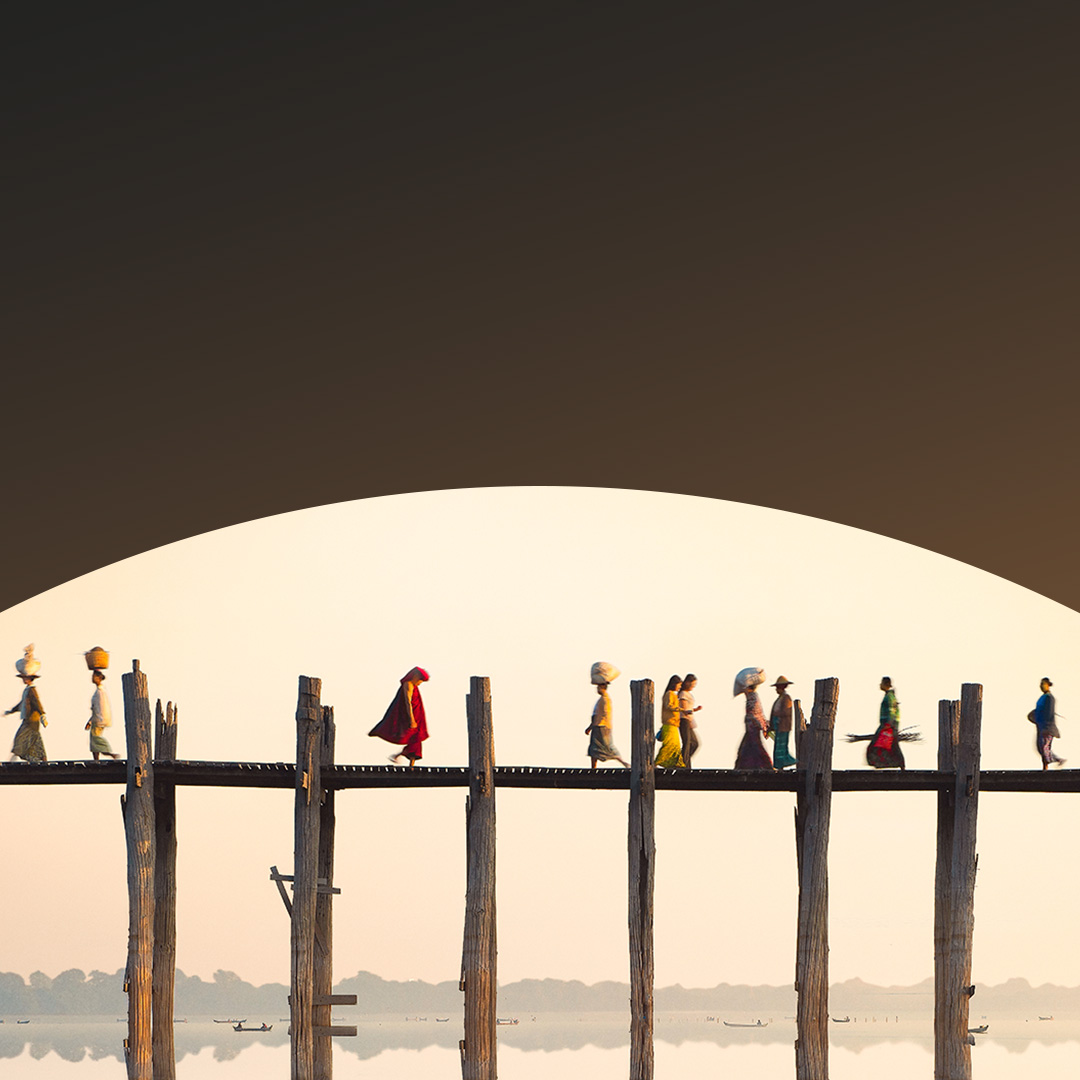 Mensen lopen over een hoge houten brug.