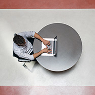 Top-down view of a man working on a laptop.
