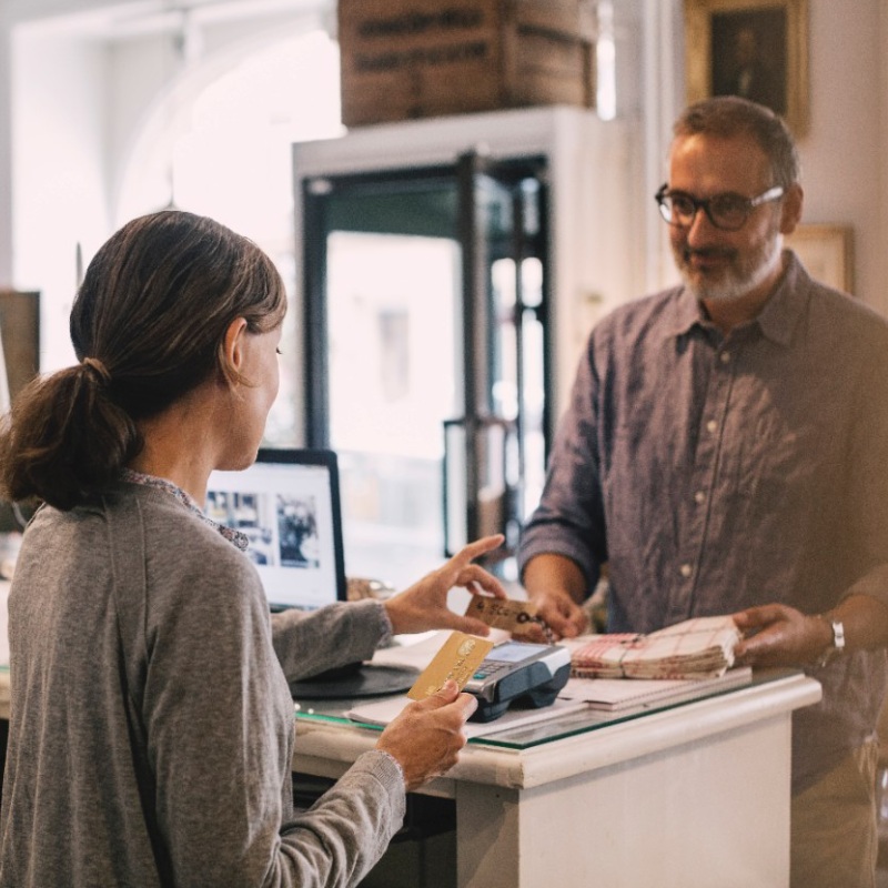 A store worker takes a customer's credit card.