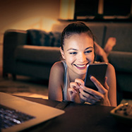 Mujer joven acostada mirando el teléfono.