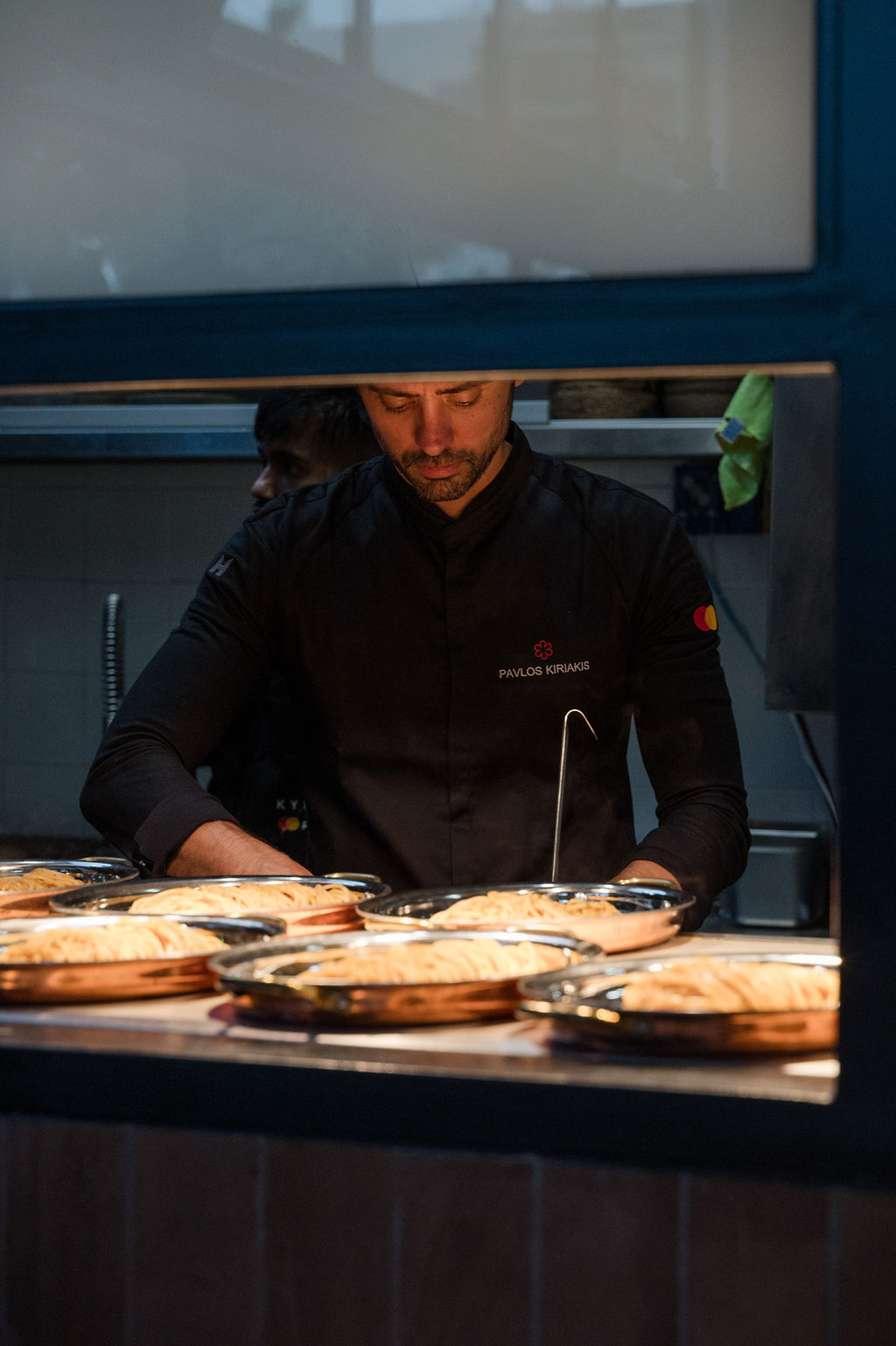 A chef works at the pass in Kykloi by Priceless.