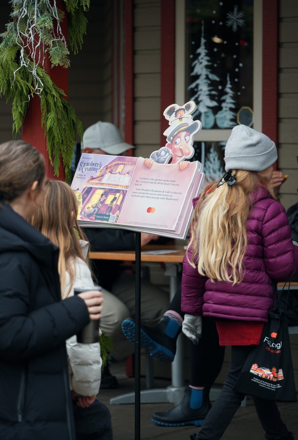 Shoppers in Fort Langley, B.C. go into a story in the town's historic city centre, past a copy of Mastercard's storybook "Cranberry & Crumm