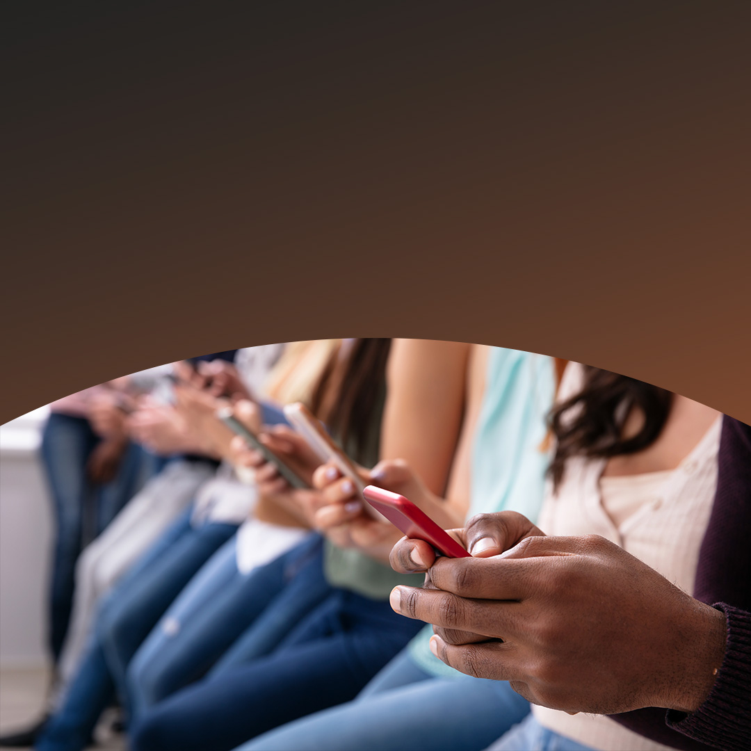 Fila de jovens a utilizar telemóveis.