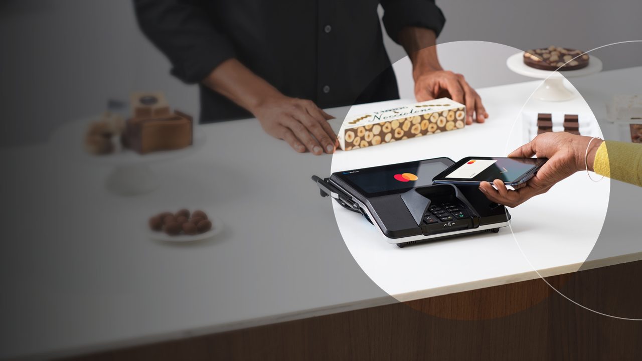 Client efectuând o plată contactless cu Mastercard, folosind telefonul.