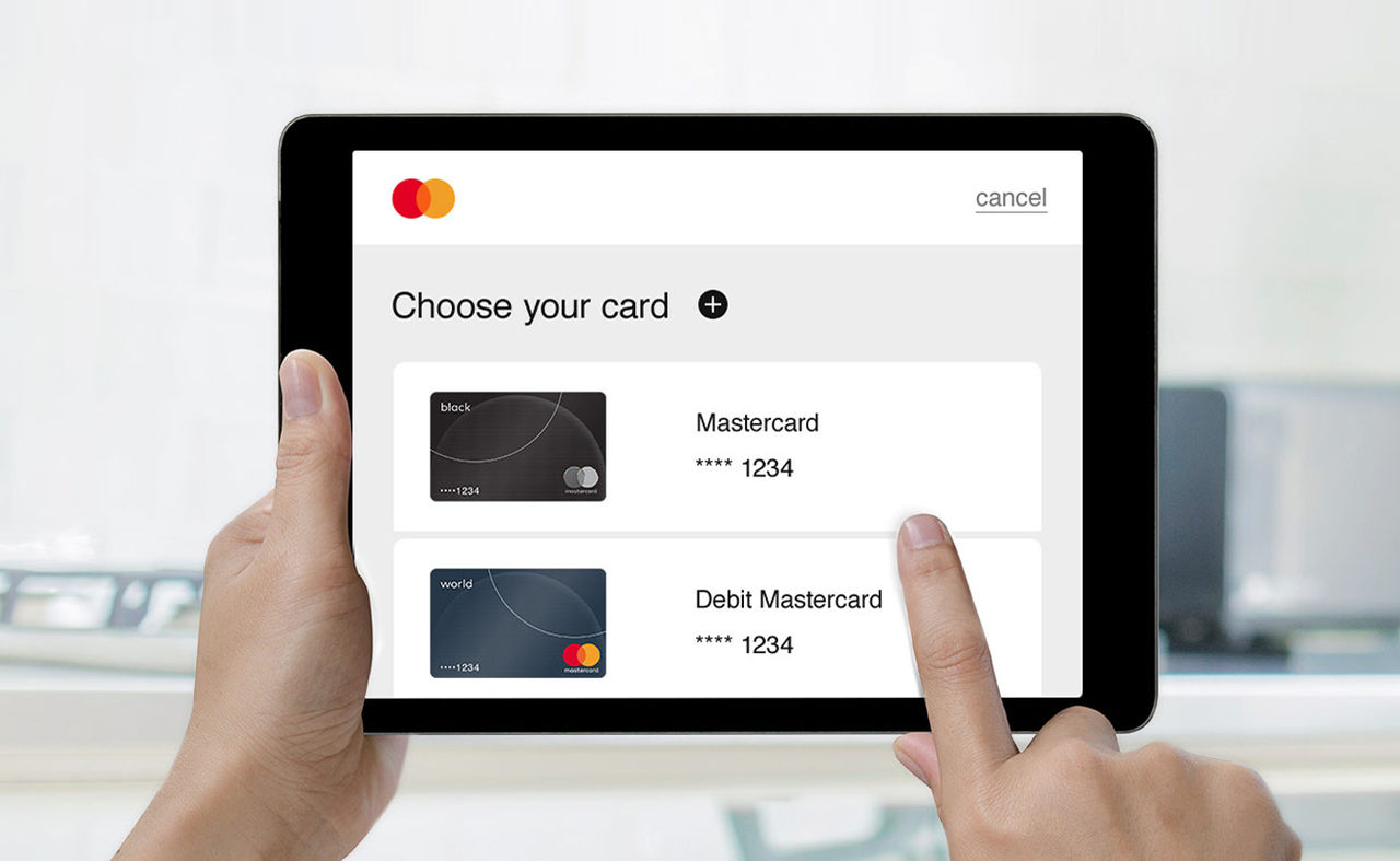 Ruke drže tablet na kojem je prikazan ekran sa naslovom „Izaberite karticu”, koji prikazuje opcije Mastercard.