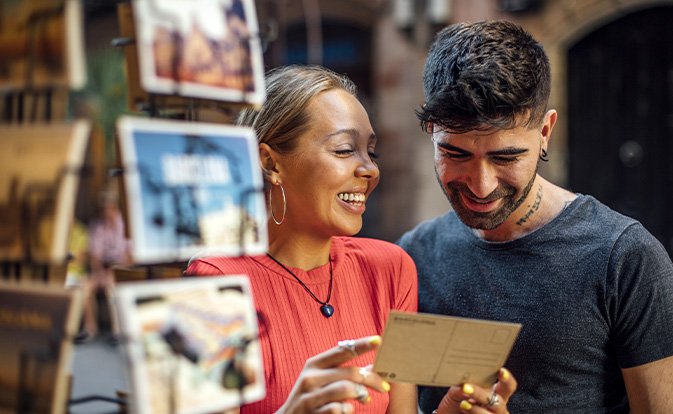 Man and woman looking at postcards during their trip