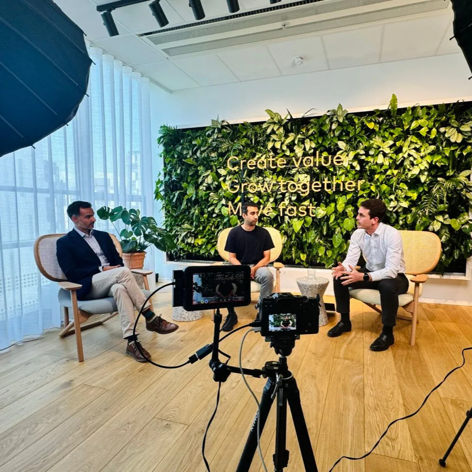 Men sitting in an office space recording a conversation.