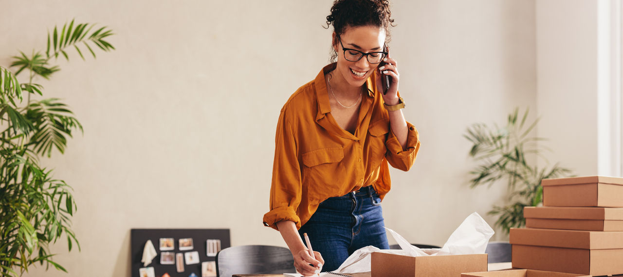 Woman on the phone doing work in her home office