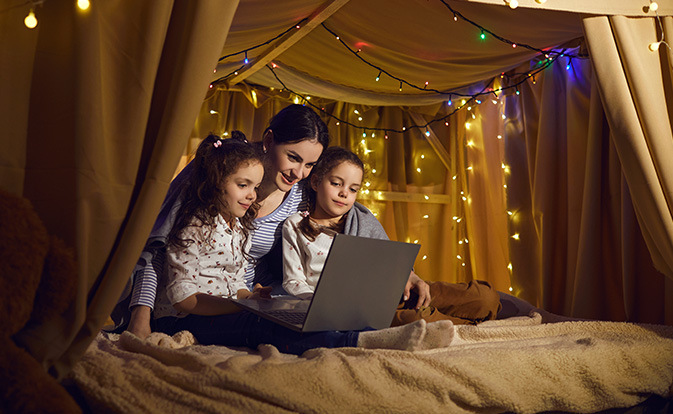 Young caucasian mother with daughters using laptop.