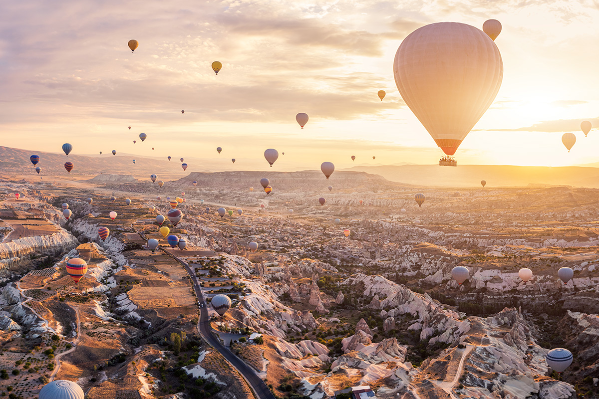 View of many hot air balloons lifting into the sky.