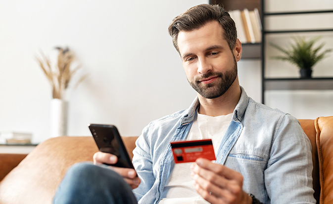 Bearded handsome man makes purchase online.