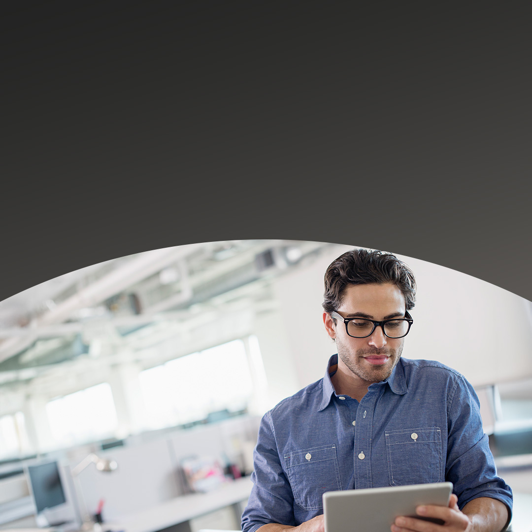 Office worker using tablet to look up latest news and events.