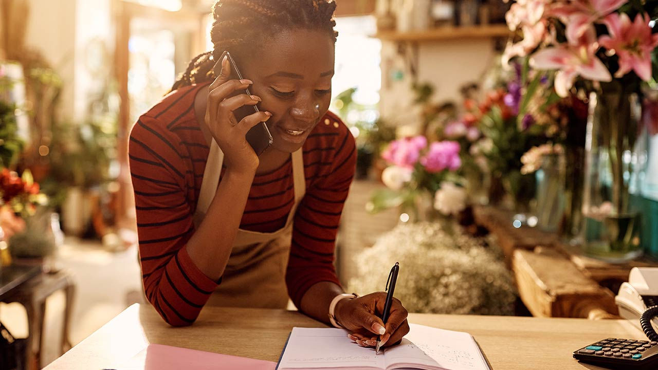 Florist taking order over the phone at flower shop.