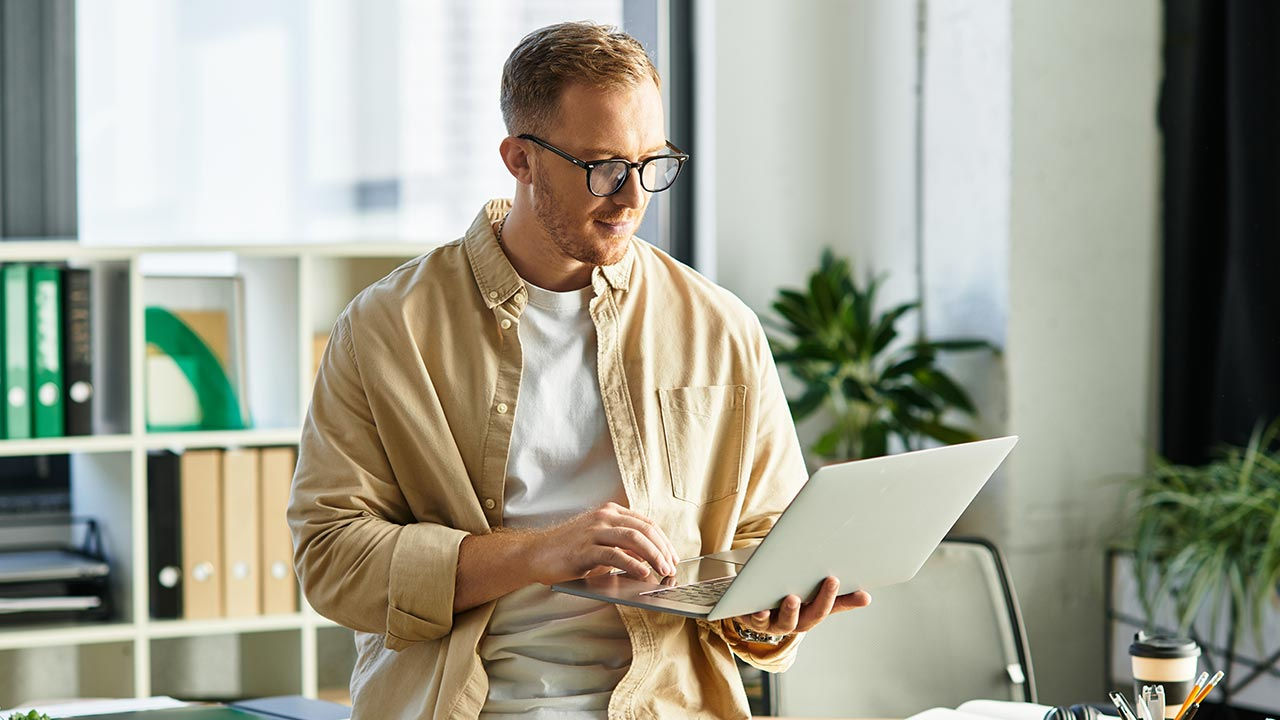 Male entrepreneur in an office with a laptop.