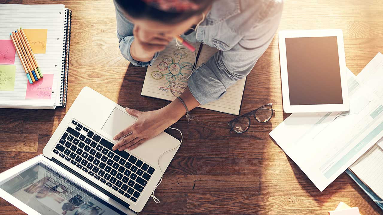 Aerial shot of woman content planning with laptop.