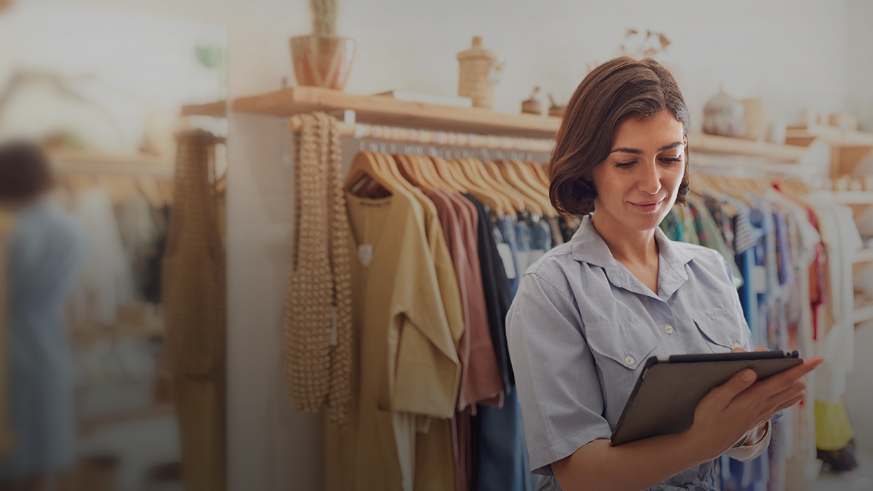 Woman owner of clothing store holding a tablet.