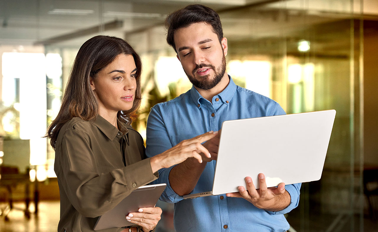men and woman looking at a computer